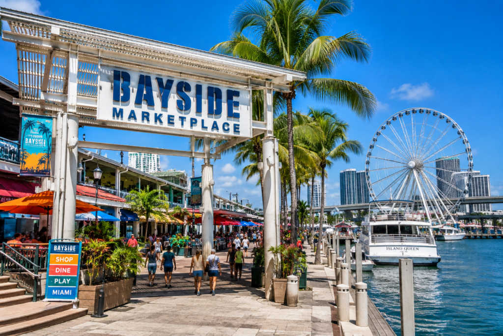 Bayside Marketplace in Miami Florida with palm trees, waterfront shops, Ferris wheel, and boats