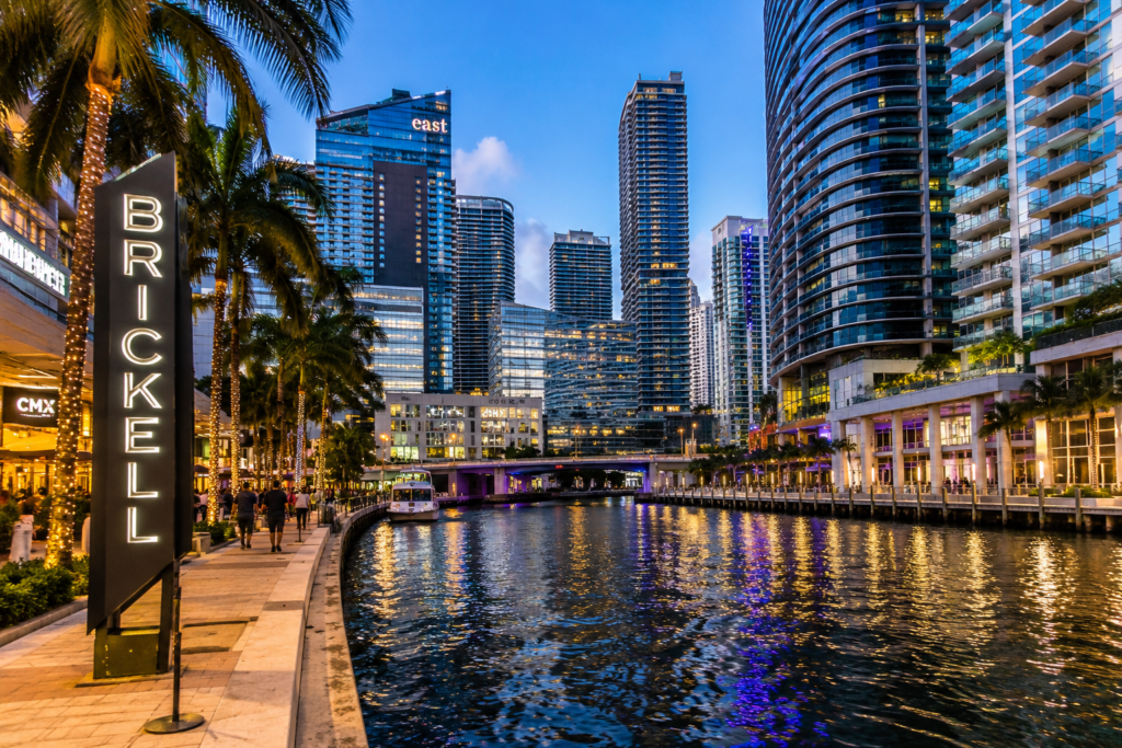 Brickell Miami Florida with modern skyscrapers, palm trees, waterfront, and city lights