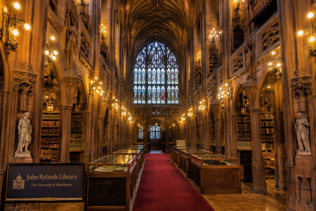 John Rylands Library in Manchester UK with neo-Gothic architecture, historic bookshelves, stained glass windows, and grand interior