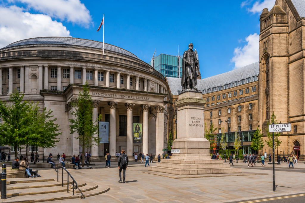 Manchester Central Library and St Peter's Square with historic architecture, Gladstone statue, public square, and visitors